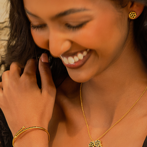 Gold-plated honeycomb bracelet with black pavé band on wrist