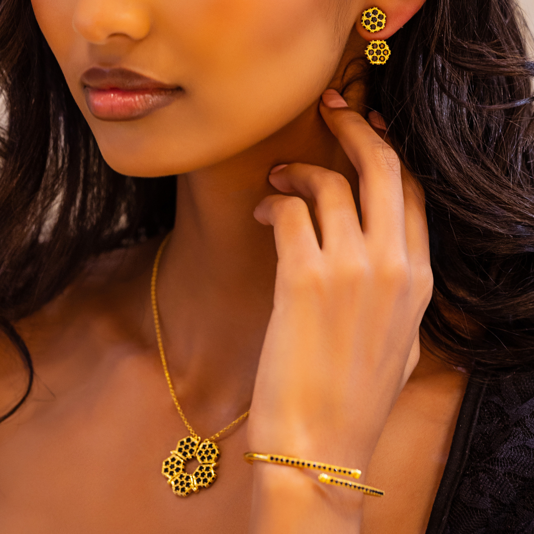 Honeycomb bracelet with gold frame and black gemstone pavé line, worn on wrist