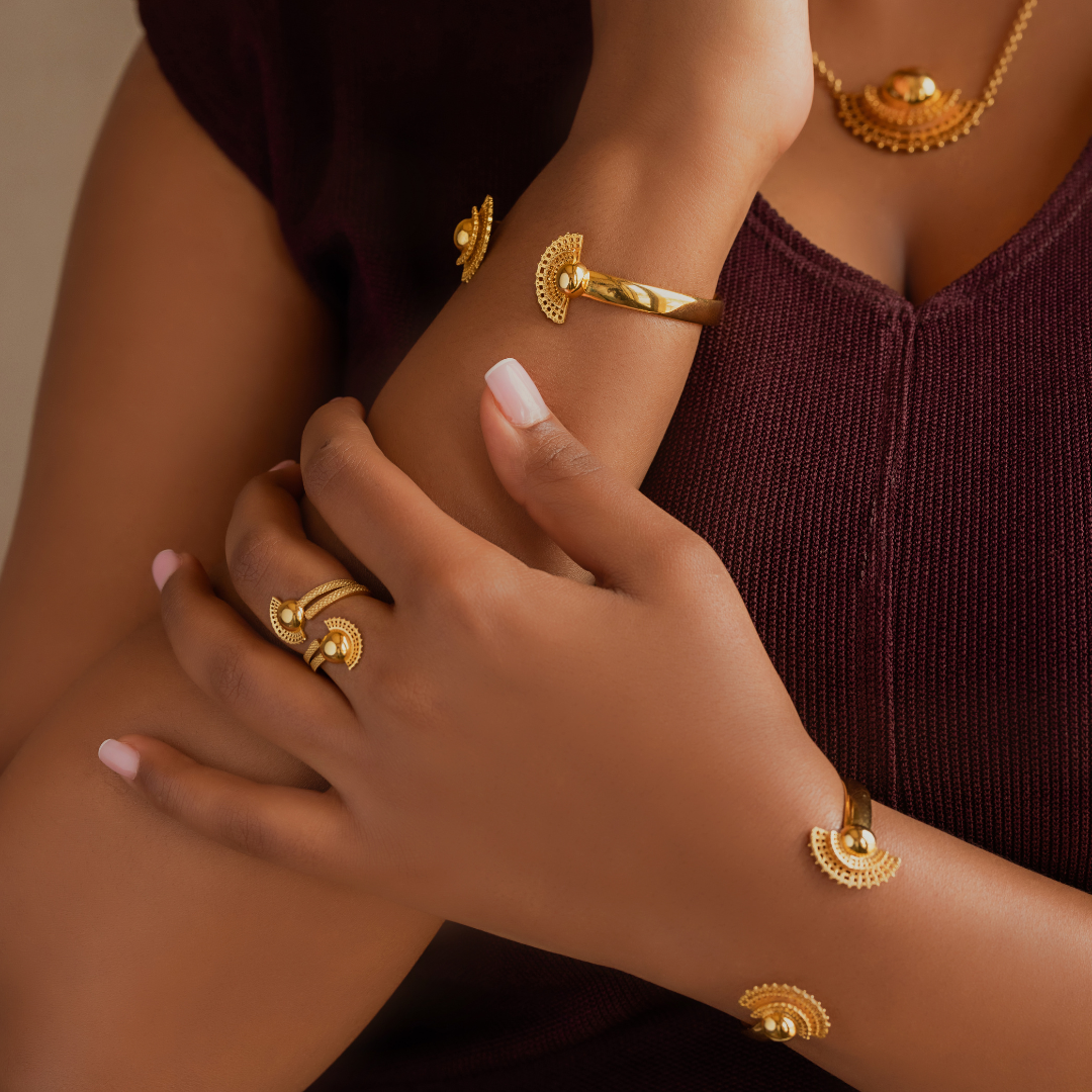 Gold-plated bracelet cuff with patterned crescent charms on model’s wrist