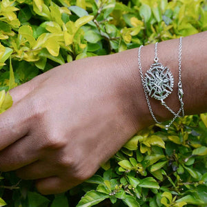 A Model's Hand Wearing Yenaé Rhodium Plated Axum Cross Necklace As Bracelet 
